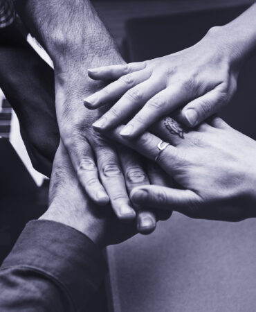 Team of business people stacking hands
