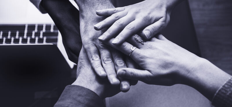 Team of business people stacking hands