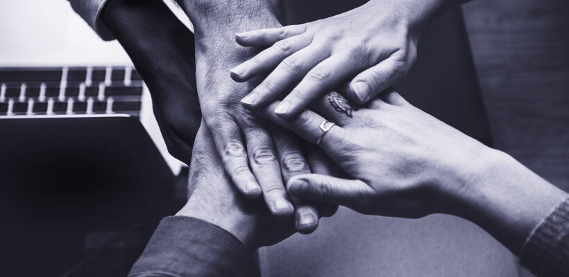 Team of business people stacking hands